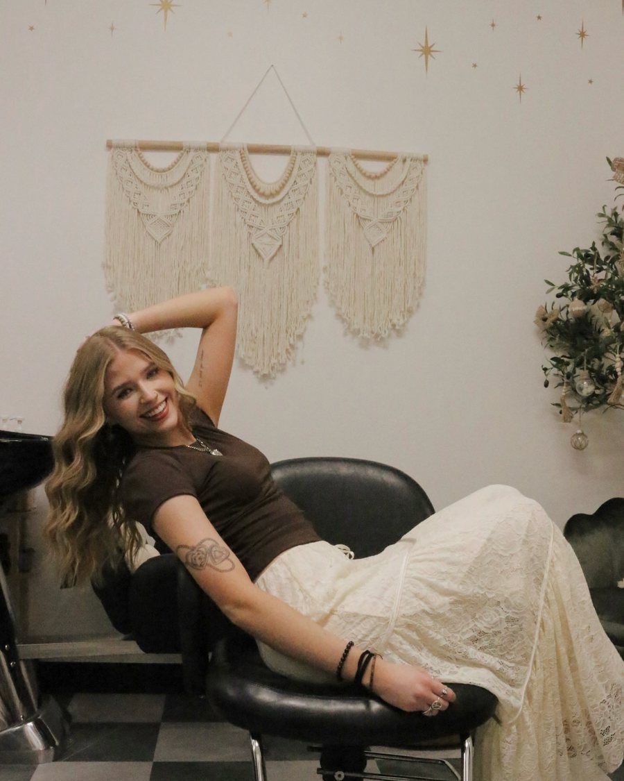 Kayla MacArthur smiling in her Sola Salon studio in Auburn, CA.