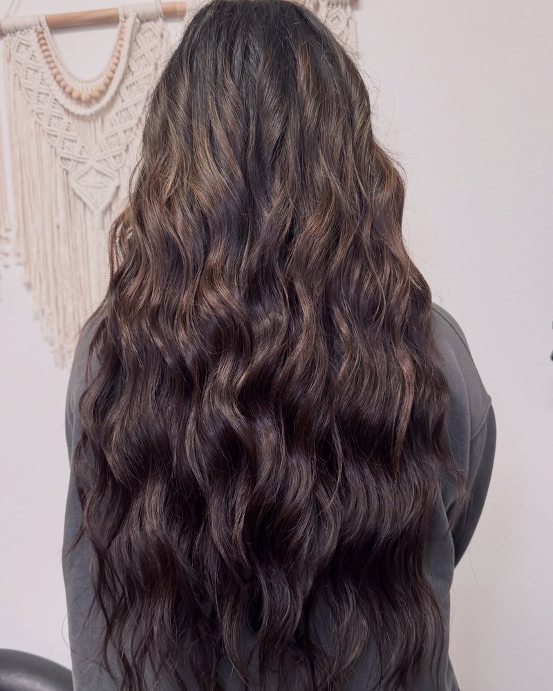 Long, full brunette lengths with the weft rows blended in and hidden — a color-matched sew-in install by Beauty by Kayla Mac in Auburn.