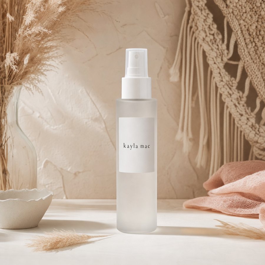 Kayla Mac Big-Day Volume Spray bottle on a cream boho backdrop.